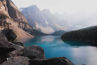 Scenic view of lake by mountains against sky