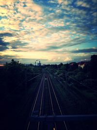 Railroad tracks against cloudy sky