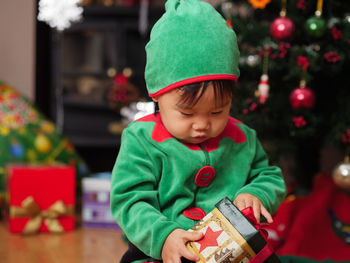 Close-up of baby girl with christmas gift at home