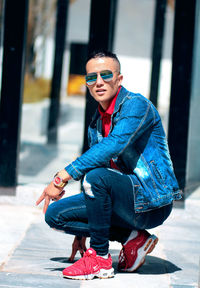 Young man wearing sunglasses sitting outdoors