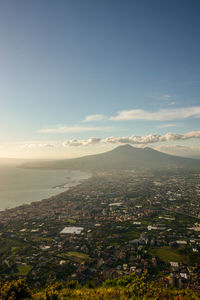 Aerial view of city by sea against sky