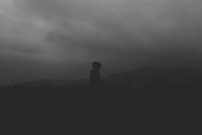 Silhouette of mountain against cloudy sky