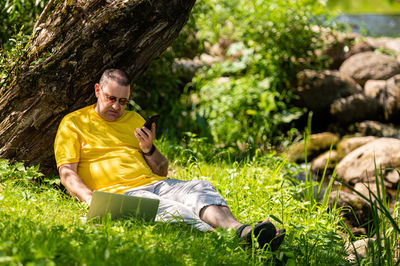 Young man sitting on rock