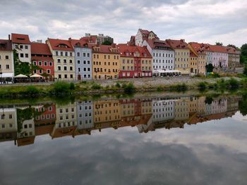 Reflection of buildings on river against sky