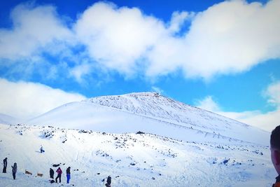 Low angle view of snow covered mountain against blue sky