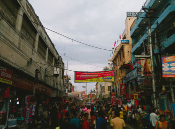 People on street in city against sky