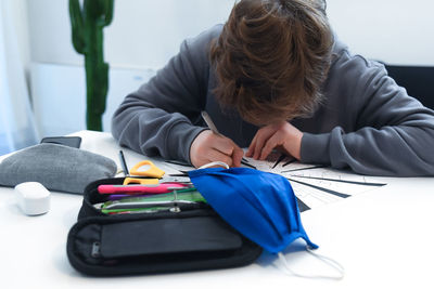 Close-up of boy studying at home