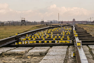 Railroad tracks by bridge against sky