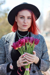 Portrait of young woman holding bouquet