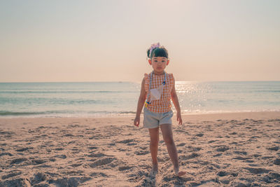 Full length of boy on beach against sky
