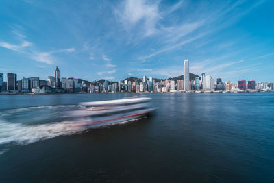 Sea by buildings against sky in city