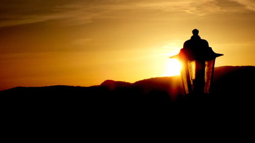 Silhouette man against sunset sky