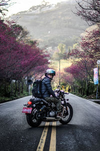 Man riding motorcycle on road in city