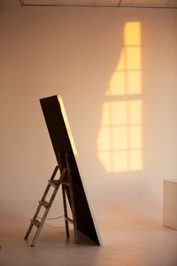Shadow of empty chair on table at home
