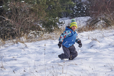 High angle view of boy walking on snow covered field during winter