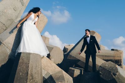 Young couple standing on road against sky