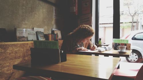 Woman sitting on table at home