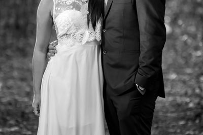 Midsection of newlywed couple standing in forest