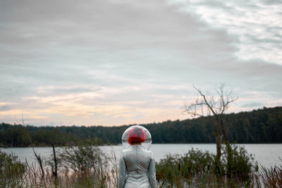 Man standing by lake against sky