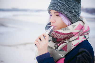 Close-up of young woman on beach during winter