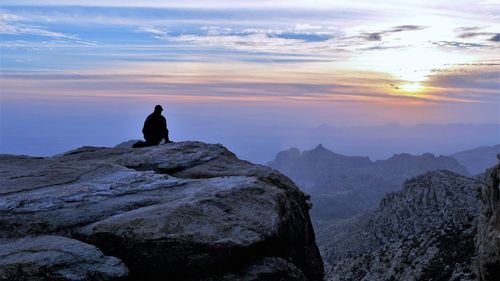Silhouette man looking at mountain against sky during sunset