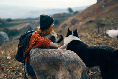 Rear view of man with dog on field