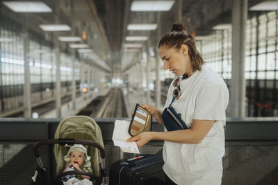 Mother with baby in stroller at train station