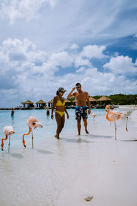 People enjoying at beach against sky