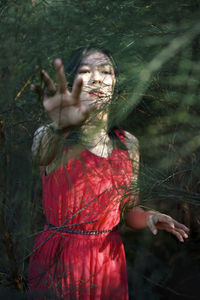 Midsection of woman with red leaf in background