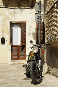 Motor scooter parked on street against building