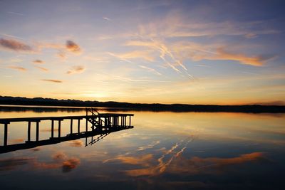 Pier on lake at sunset