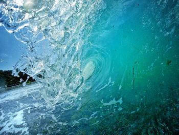 Glassy breaking turquoise wave with beach in the background. surf photography.