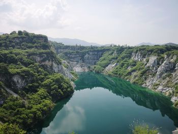 Scenic view of river amidst trees against sky