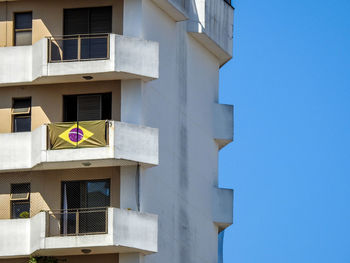 Low angle view of brazilian flag on balcony during sunny day