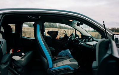 Young boy playing with his toy in the drivers seat in an electric car