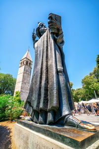 Low angle view of statue against blue sky