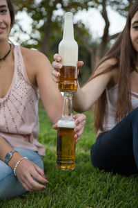 Cropped image of friends holding beer bottles