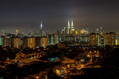 Illuminated cityscape against sky at night