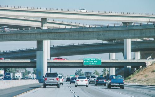 Road by bridge in city against clear sky