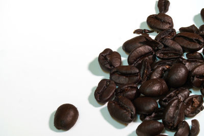 High angle view of coffee beans against white background