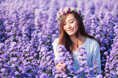 Portrait of a beautiful young woman with purple flower