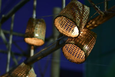 Low angle view of illuminated lighting equipment hanging from ceiling