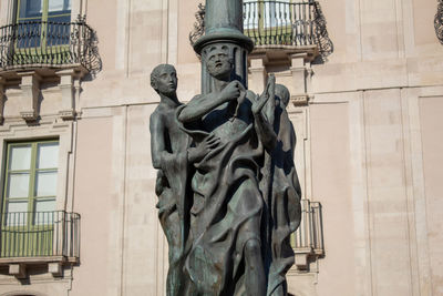 Sculptures integrated into a street lamp