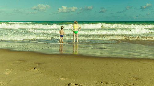 People enjoying at beach against sky