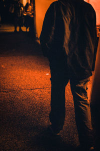 Low section of man standing on silhouette at sunset