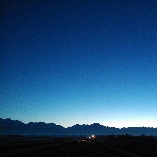 mountain, clear sky, copy space, landscape, blue, mountain range, tranquil scene, tranquility, scenics, road, beauty in nature, transportation, nature, non-urban scene, dusk, outdoors, silhouette, remote, idyllic, horizon over land