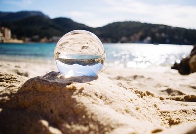 Close-up of crystal ball on beach