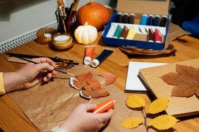 Autumn craft from dried leaves. diy fall crafts for adults. fall nature collage. female hands