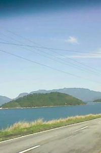 Road by mountains against sky