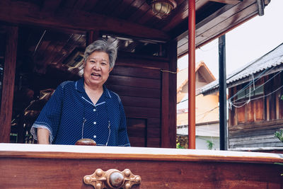 Portrait of a smiling senior woman standing tran